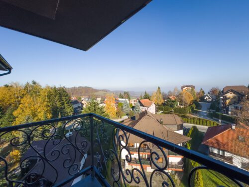 Zlatibor apartmani – Pogled iz spavaće sobe na terasu i prirodu – Moderan apartman sa velikim staklenim površinama koje povezuju unutrašnjost i eksterijer.